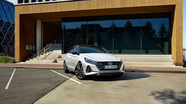 Zcela nový Hyundai i20 N Line před budovou s velkými okny.